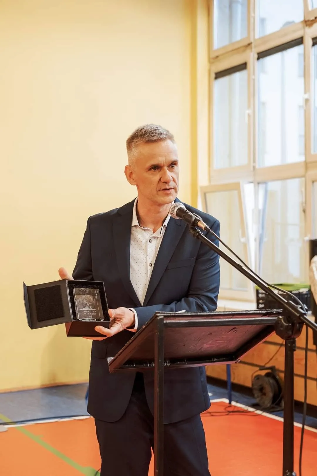 Tomasz Cygal przy mikrofonie prezentuje statuetkę Nagrody im. Marcina Wierzby.